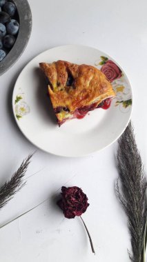 Masanın üzerinde yeni pişmiş bir dilim yaban mersinli turtanın dikey yakın çekimi.