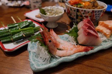 Ahşap bir masada geleneksel Japon Sashimi 'sinin yakın çekimi.