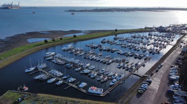 Limandaki ahşap rıhtımın yakınındaki gemilerin ve teknelerin insansız hava aracı görüntüsü.