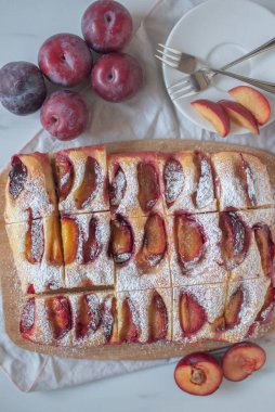 Lezzetli taze erikli turta ve masada çiğ eriklerin dikey görüntüsü.