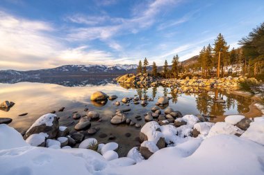 Amerika 'da yeşillik ve karla çevrili Tahoe Gölü manzarası.