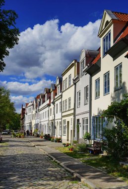 Lubeck, Almanya 'da bir yaz günü geleneksel binaların ve yemyeşil ağaçların dikey kentsel görüntüsü