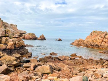 Denize bakan dik kumtaşı oluşumlarıyla kayalık bir kıyı manzarası.