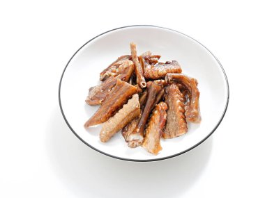 Beyaz arka planda izole edilmiş tabakta kızarmış tavuk kanatlarının yakın çekimi.