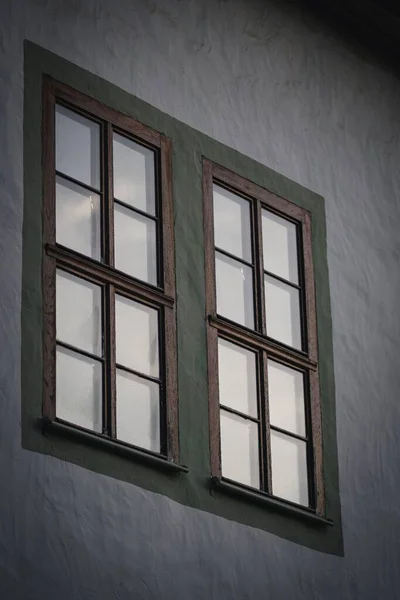 灰色建筑物上的一个旧的绿色木制窗户的低角照片 — 图库照片
