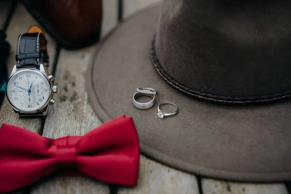 帽沿上有订婚戒指 手表和红色领结的男帽的特写镜头 — 图库照片