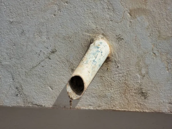 Gri Bir Duvardan Sarkan Eski Bir Çelik Borunun Yakın Çekimi — Stok fotoğraf