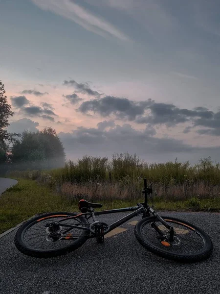 Arka Planda Dramatik Bulutlu Bir Gökyüzü Olan Otoyolda Bir Bisikletin — Stok fotoğraf