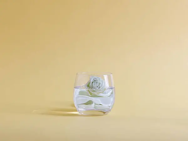 白いバラの繊細な水のガラスの塊がパステルイエローの背景に孤立しています — ストック写真