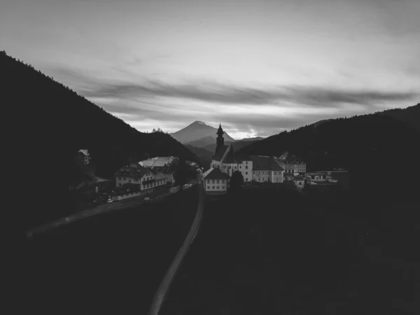 stock image A drone grayscale shot of cloudy sky on a small rural village in the Austrian mountains