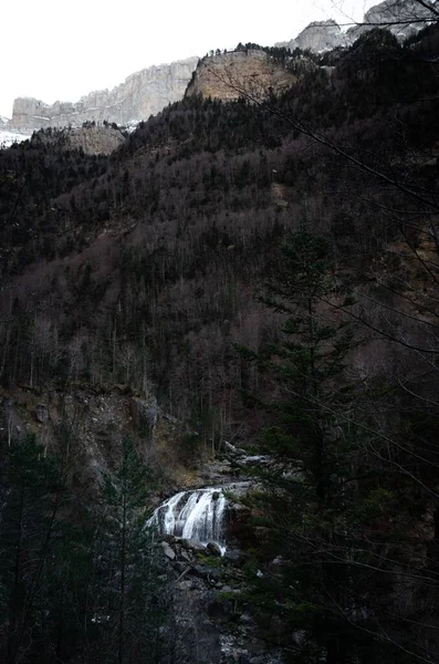 Pionowe Ujęcie Wodospadu Otoczonego Skalistymi Górami Lasami Świetle Dnia — Zdjęcie stockowe