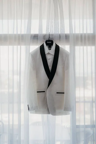 一套挂在窗上的黑色白色新郎套装的垂直照片 — 图库照片