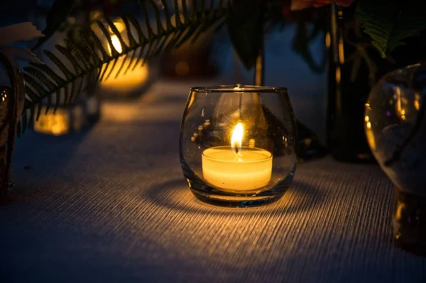 Nahaufnahme Einer Brennenden Gelben Kerze Einem Glas Auf Einem Tisch — Stockfoto