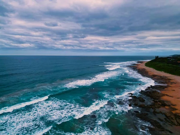 曇り空を背景に岩場の海岸線を望む青い海の絶景 — ストック写真