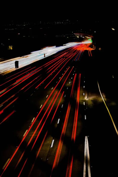 夜に道路上の車のライトの垂直長時間露光ショット — ストック写真