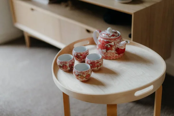 丸みを帯びた木製のテーブルの上にティーポットとティーカップのクローズ — ストック写真