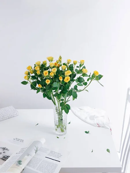 Vertikální Záběr Krásné Kytice Růží Skleněné Váze Bílém Stole Časopisem — Stock fotografie