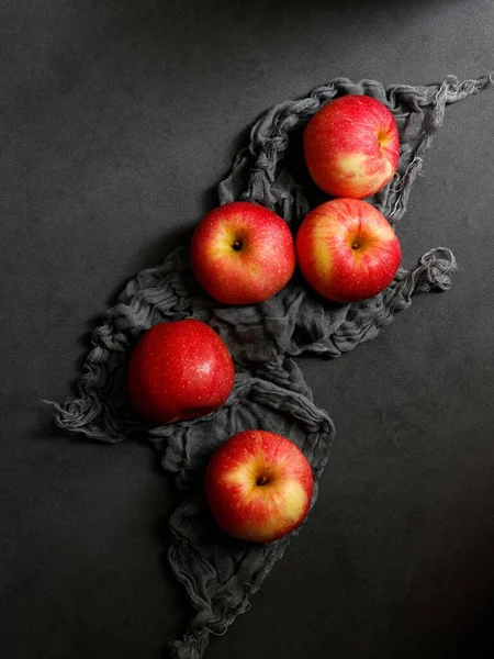 Vertikální Záběr Červených Jablek Černou Látkou Černém Stole — Stock fotografie