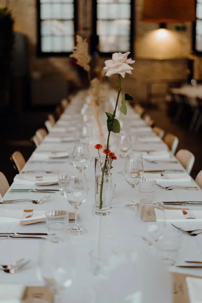 結婚式会場で花の装飾が施されたディナーテーブルの垂直ショット — ストック写真
