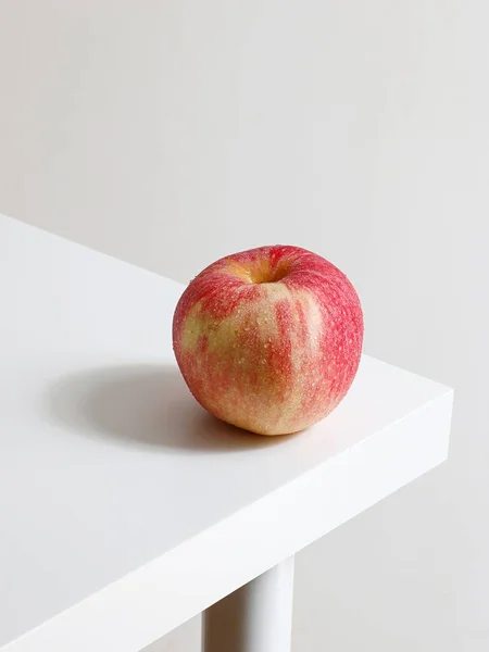 Plan Rapproché Une Pomme Rouge Coin Une Table Blanche — Photo