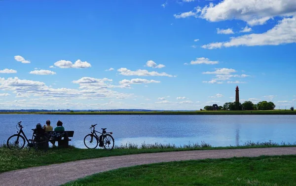 Bild Väg För Cyklar Två Personer Sitter Bänk Framför Vattenyta — Stockfoto