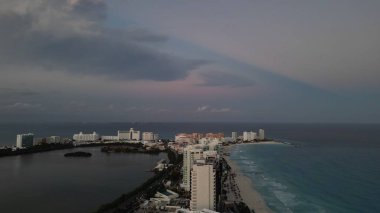 Gün batımında binalar ve suyla çevrili Miami şehir manzarası.