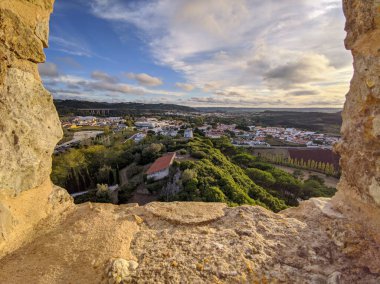 Eski bir taş pencereden görülen Obidos kasabası