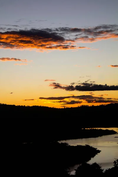 Een Silhouet Van Heuvels Een Rivier Tijdens Zonsondergang — Stockfoto