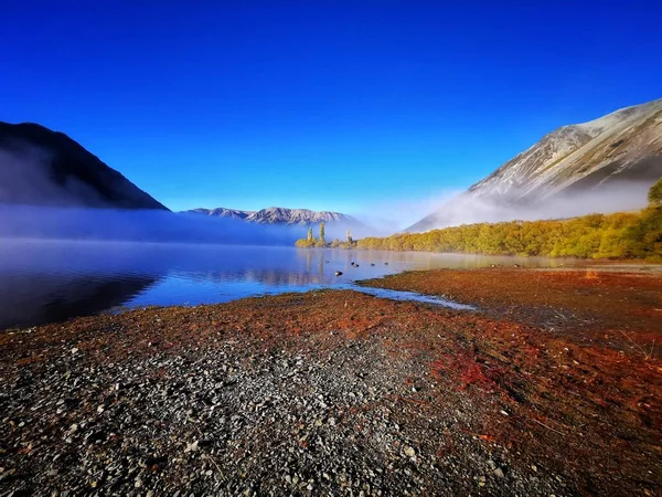 ニュージーランドのピアソン湖の風光明媚なショット山と背景に近づいて霧 — ストック写真
