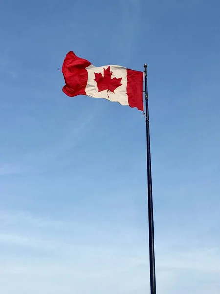A vertical shot of the waving Canadian flag