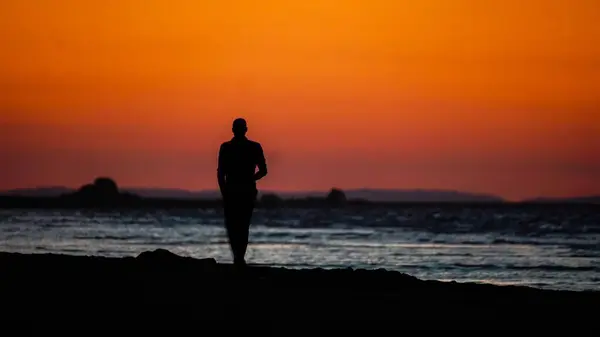 Silhouette Eines Mannes Der Bei Sonnenuntergang Strand Spaziert — Stockfoto