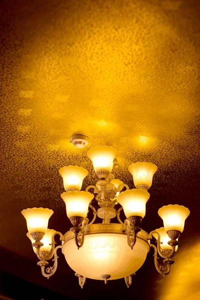 Низкоугольный Снимок Роскошной Винтажной Люстры Висящей Потолке Множеством Включенных Лампочек — стоковое фото
