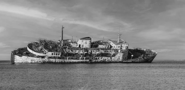 灰色の曇り空の下で海の錆びた放棄された船 グレースケールショット — ストック写真