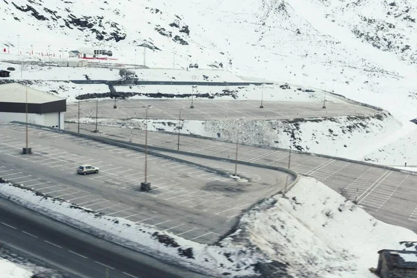 Flygbild Parkeringsplats Och Enda Bil Parkerad Där Omgiven Snöiga Kullar — Stockfoto