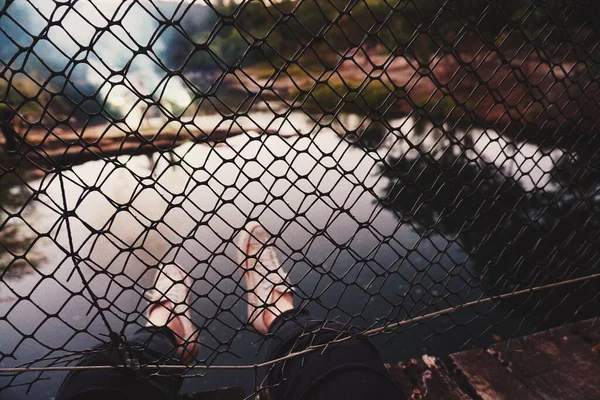 Ένα Άτομο Κρέμεται Κάτω Από Ένα Φράχτη Πάνω Από Λίμνη — Φωτογραφία Αρχείου