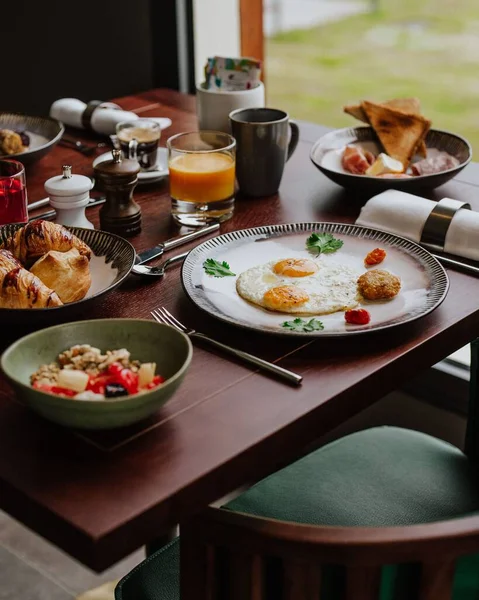 Finom Reggeli Egy Fából Készült Asztalra Tojással Croissant Zabpehely Saláta — Stock Fotó