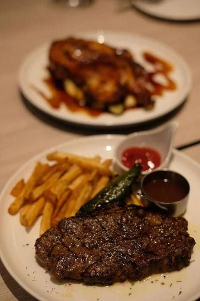 白いプレートの上においしいステーキとフライドポテト — ストック写真