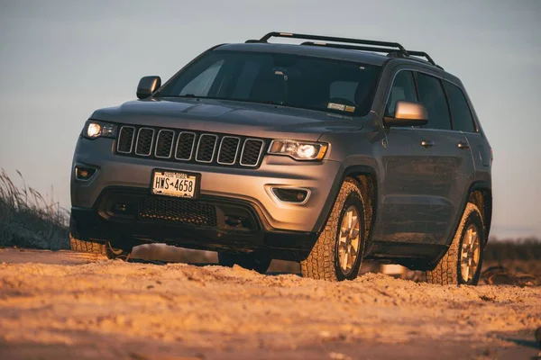 stock image A gray 2018 Jeep Grand Cherokee at the beach at sunset