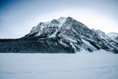 Dağlık bir arka planda karla kaplı bir arazinin ürpertici görüntüsü