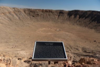 Bir plaka, Meteor Krateri, Winslow, AZ, ABD 'deki bir meteorun çarpma noktasını anlatıyor.