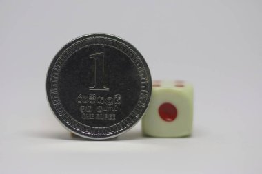 Yuvarlak şekilli bir Sri Lanka parası. Üzerinde beyaz bir zar bulunan bir rupi.