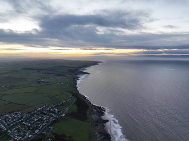Ogmore sahilinin üzerindeki altın gün doğumunun büyüleyici görüntüsü.