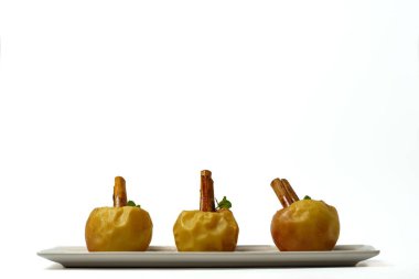 baked apples with cinnamon and syrup isolated on white background