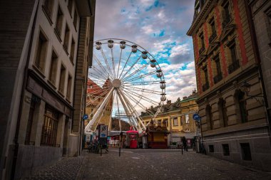 Lozan 'da binalarla çevrili bir dönme dolap.