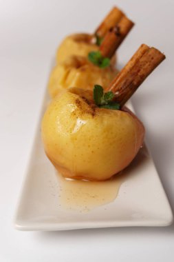 baked apples with cinnamon and syrup isolated on white background