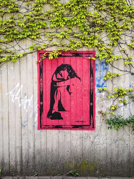 ツタで覆われた壁に黒と赤の色で絶望の女性の壁の芸術の垂直ショット — ストック写真