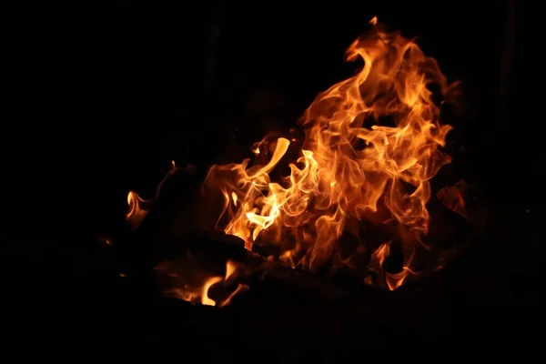 暗闇の中で明るいオレンジの炎を燃やすクローズアップショット — ストック写真