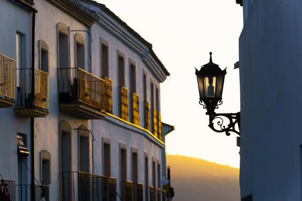 夕暮れ時の街灯のある通り山のある黄色の背景 — ストック写真