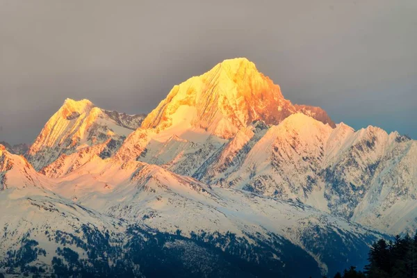 Ένα Μαγευτικό Τοπίο Χιονισμένων Βουνών Ήλιο Στις Κορυφές — Φωτογραφία Αρχείου