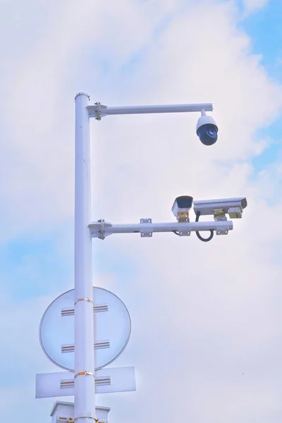 光とセキュリティカメラ付きホワイトメタルポールの垂直ショット — ストック写真